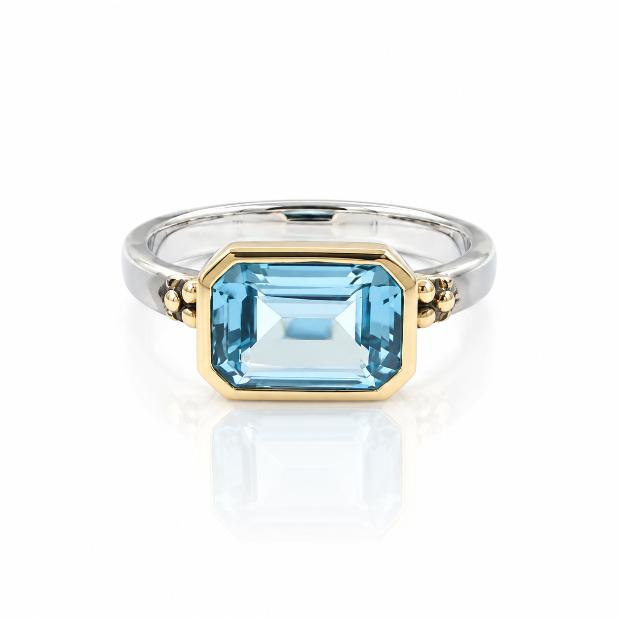 BSwiss lue topaz east west ring.  mixed metal.  on white ground. 