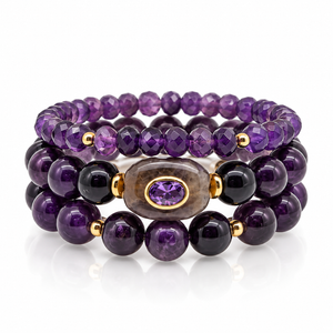 Three-piece Amethyst Stack bracelet set with smooth and faceted purple beads, gold-tone accents, and an oval centerpiece on a white background.


